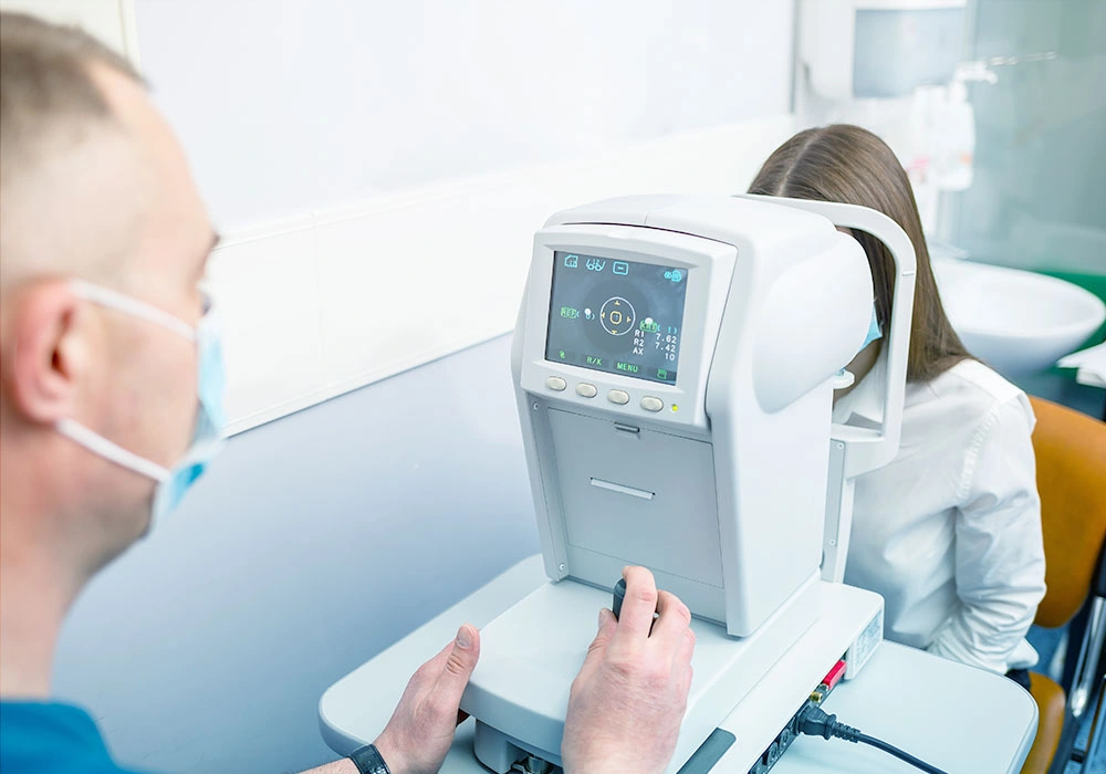 Patient undergoing a comprehensive eye exam with modern equipment to determine the ideal Vision Correction Option prior to vision correction surgery.